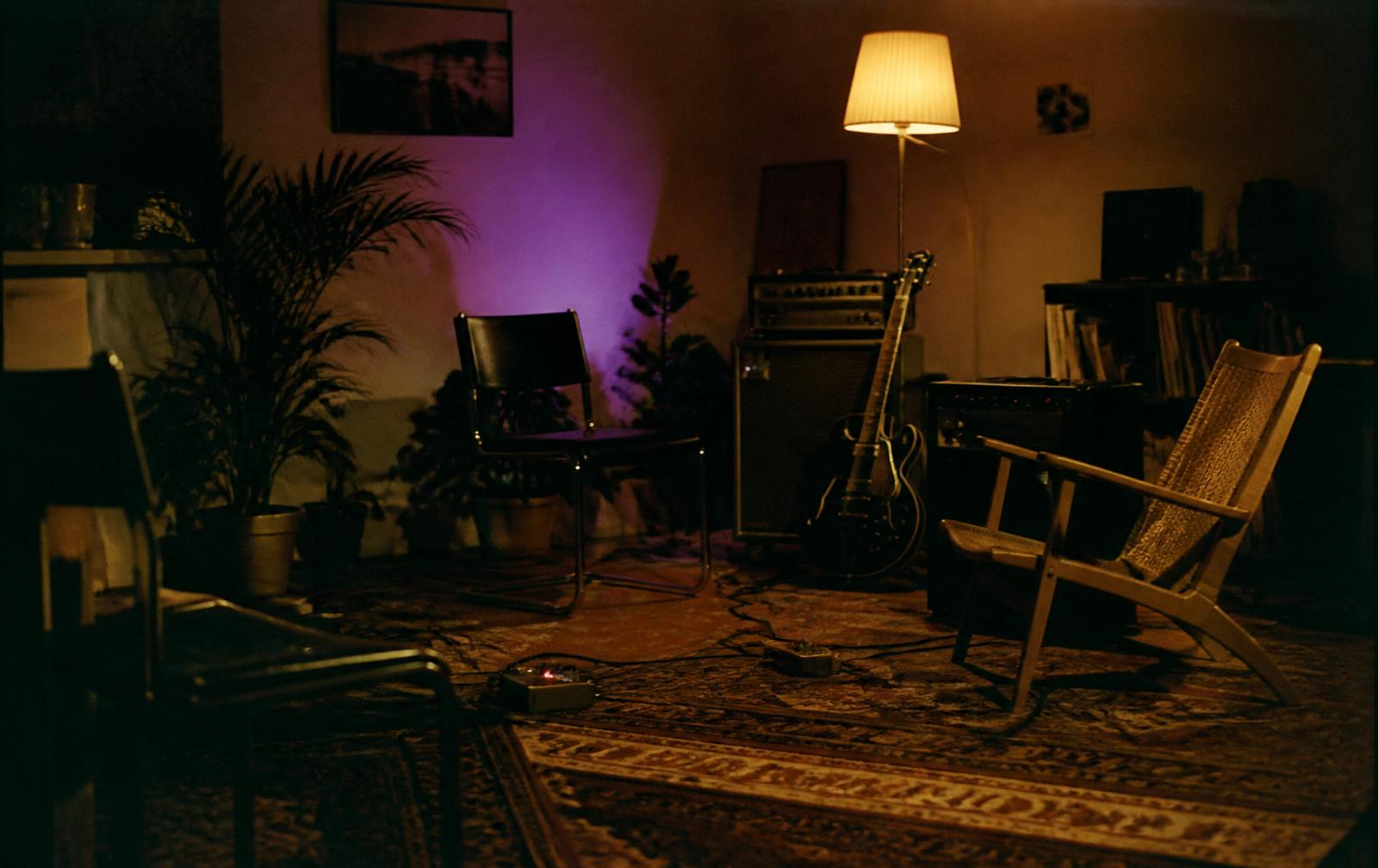 Sala de Session vazia com amplificador, guitarra e luminária âmbar